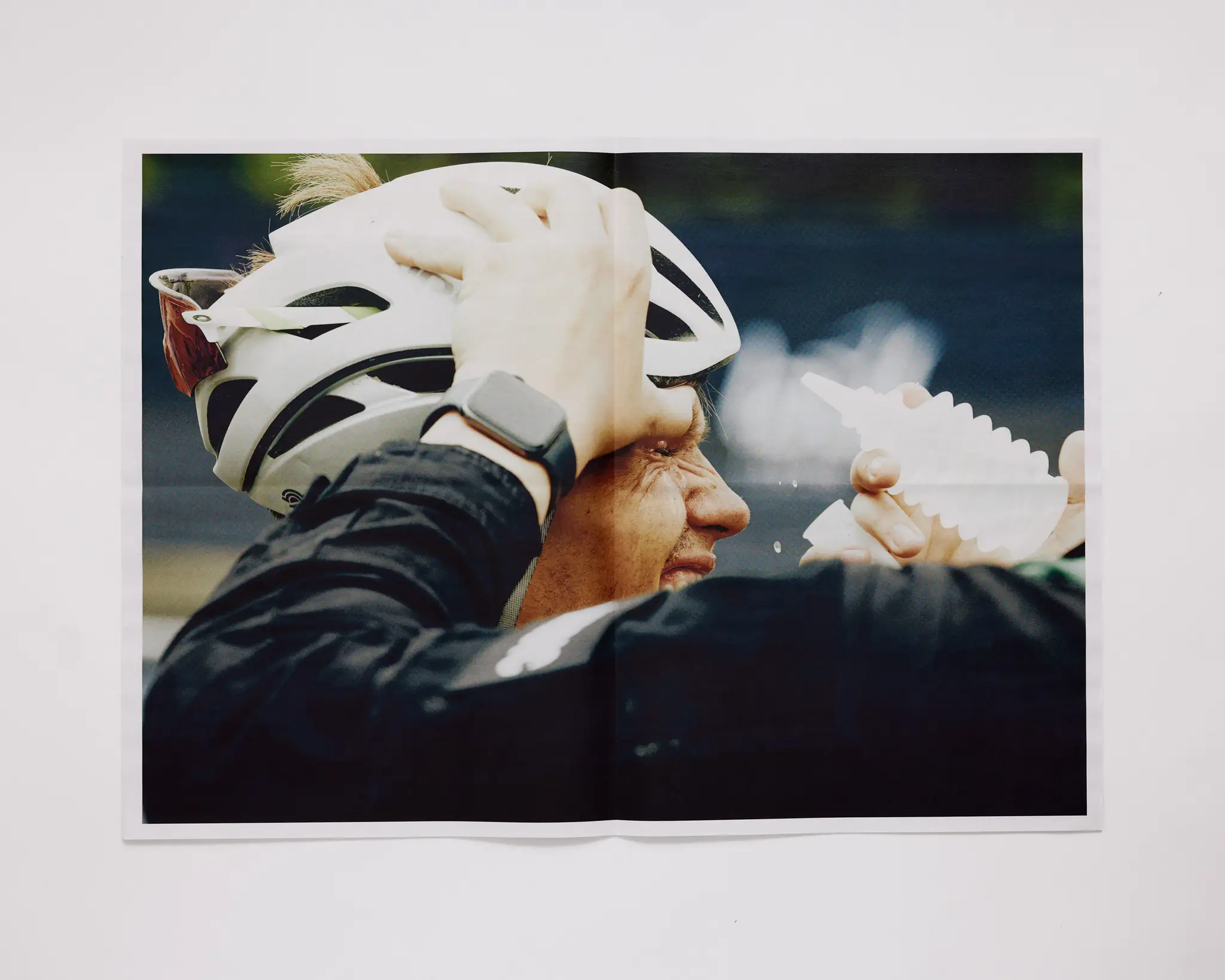 Bike racer getting his eyes washed out by medic after completing The Rift gravel bike race. The Rift gravel bike race takes place in Iceland annually. Shot for a personal project and self-published tabloid size newsprint that covers The Rift Gravel Bike Race in Iceland in 2023.