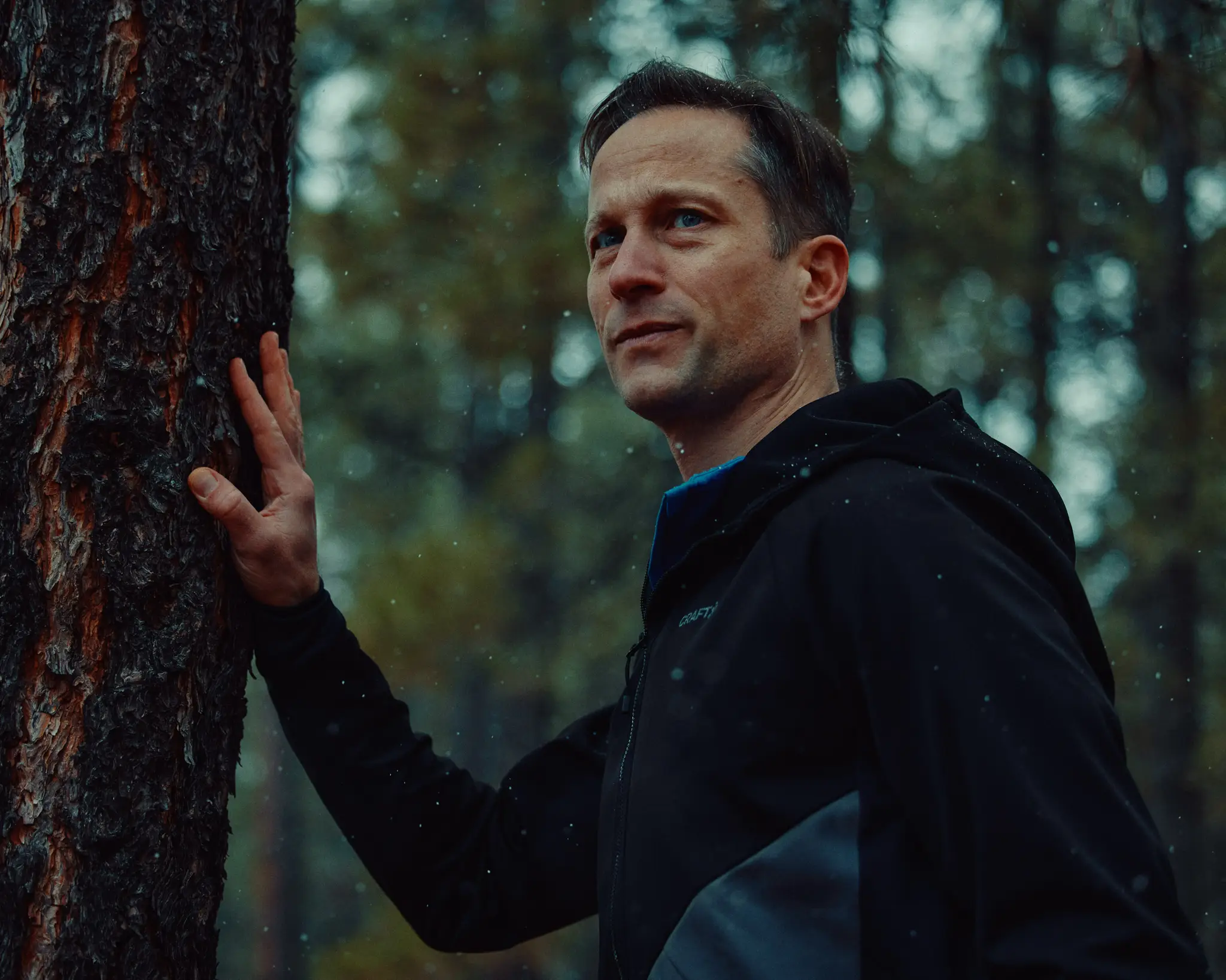 Athlete leaning against a tree set against a snowy forest in Flagstaff, AZ. Dream Run Camp features the running camp hosted by Michael Fitzgerald, a runner living with long covid, that's hosted in Flagstaff, AZ. This commission was originally commissioned by The New York Times.